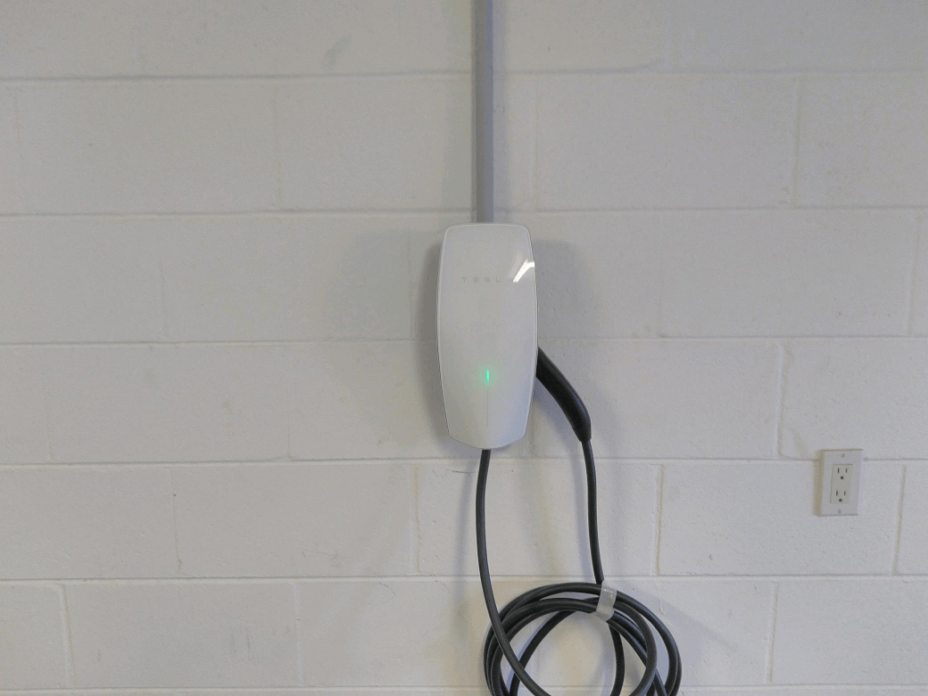 New Dawn Electric Wall-mounted electric vehicle charger with coiled cable, available in Sarasota and Manatee County. New Dawn Electric Wall-mounted electric vehicle charger with coiled cable, available in Sarasota and Manatee County.