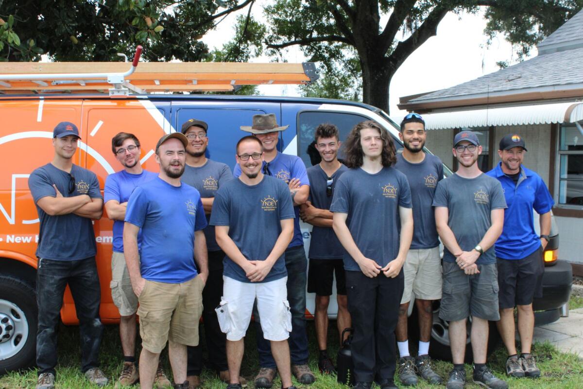 New Dawn Electric apprentices proudly standing in front of the company work van, showcasing our commitment to training and developing future electricians in Bradenton and Sarasota.